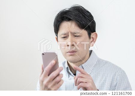 Man having difficulty seeing smartphone screen, presbyopia, eye strain, tired eyes 121161700