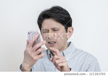 Man having difficulty seeing smartphone screen, presbyopia, eye strain, tired eyes Man having difficulty seeing smartphone screen, presbyopia, eye strain, tired eyes 121161703
