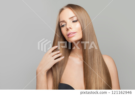 Elegant woman face. Model with long brown hair and make-up on grey background. Elegant woman face. Model with long brown hair and make-up on grey background. 121162946