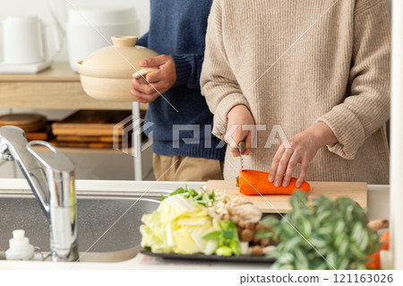 A middle-aged couple preparing hotpot in the kitchen A middle-aged couple preparing hotpot in the kitchen 121163026
