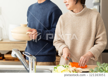 A middle-aged couple preparing hotpot in the kitchen A middle-aged couple preparing hotpot in the kitchen 121163051