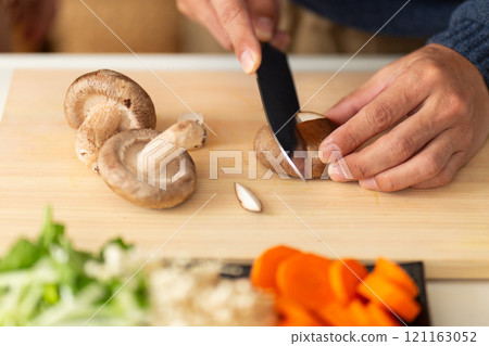 一名中年男子在廚房切香菇的手 121163052