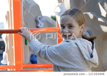 Close-up portrait of child girl on playground. Kids play outdoor 121163946