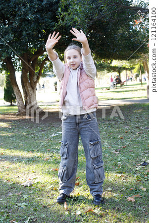 Active child girl catching flying disc in park. Happiness and childhood concept Active child girl catching flying disc in park. Happiness and childhood concept 121164100