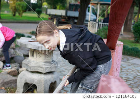 Lovely young girl. Child on playground. Kids play outdoors. 121164105