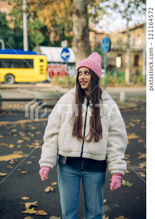 A Young Woman in a Stylish Winter Outfit Enjoying the Outdoors in an Urban Setting 121164572