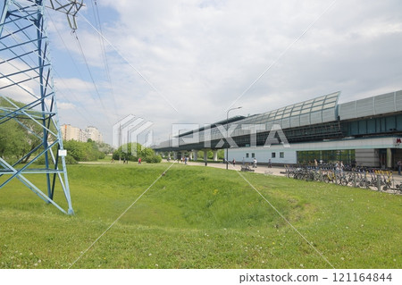 Curved sidewalk, walkway, trail in the city park. Skytrain overpass. Green background. Urbanism. Curved sidewalk, walkway, trail in the city park. Skytrain overpass. Green background. Urbanism. 121164844