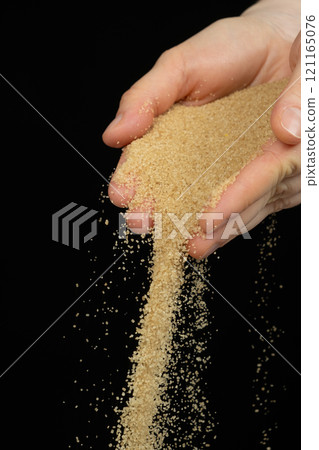 Hands pour crystalline cane brown unrefined healthy demerara sugar 121165076