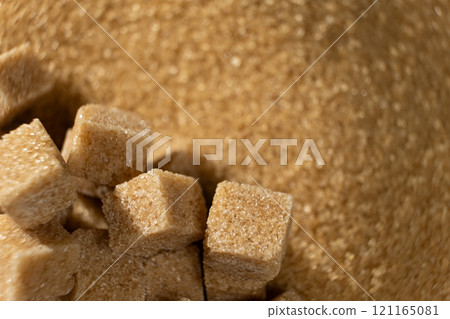 Brown cane unrefined demerara sugar in the form of crystals and cubes 121165081