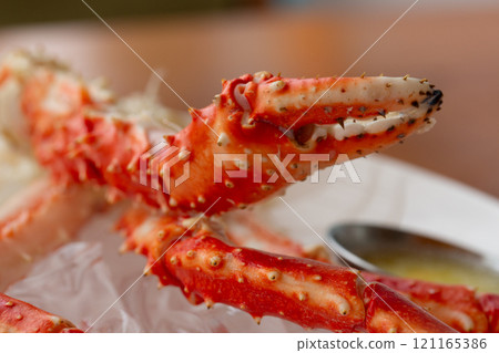 Claws of the crab Paralithodes camtschaticus on a white plate in a restaurant. Contain cholesterol, but low in saturated fat and also have omega-3 fatty acid. 121165386