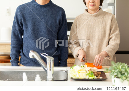 A middle-aged couple preparing hotpot in the kitchen A middle-aged couple preparing hotpot in the kitchen 121165467