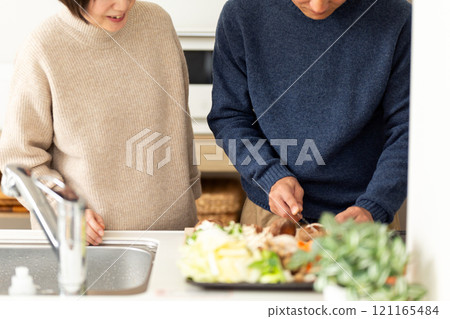 A middle-aged couple preparing hotpot in the kitchen 121165484