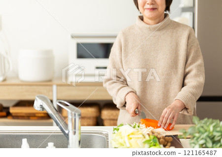 Middle-aged to senior women preparing hotpot dishes in the kitchen 121165487
