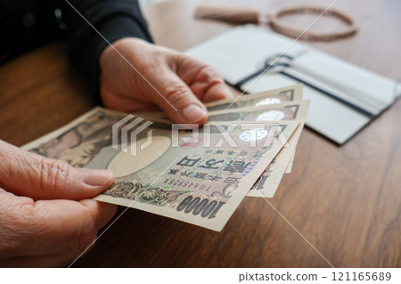 Senior woman's hands preparing a funeral offering 121165689