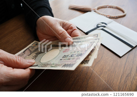 Senior woman's hands preparing a funeral offering 121165690