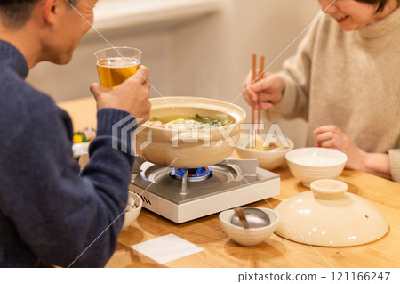 冬夜，一對中年夫妻在客廳享用火鍋晚餐 121166247