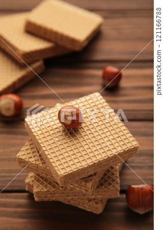 Chocolate wafers on brown background with hazelnut. Vertical photo. Chocolate wafers on brown background with hazelnut. Vertical photo. 121166788