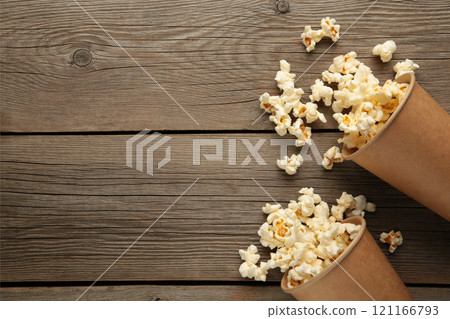Popcorn in brown cups. Two cups of popcorn on grey wooden background. Sweet popcorn. 121166793