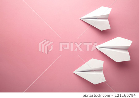 White paper airplanes on a pink background 121166794