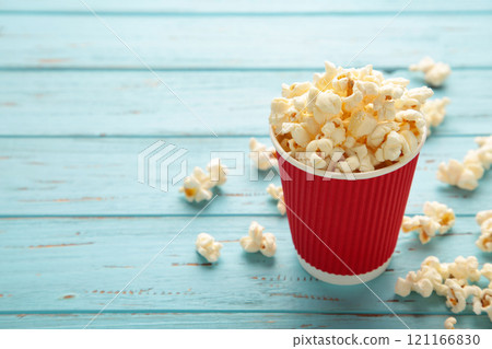 Delicious popcorn on light blue background. Space for text Delicious popcorn on light blue background. Space for text 121166830