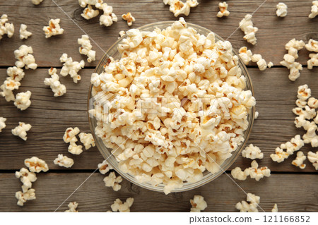 Popcorn in glass bowl on grey wooden background. 121166852