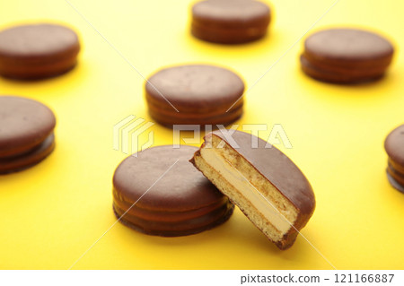 Choco pie chocolate coated snacks on yellow background with copy space. Choco pie chocolate coated snacks on yellow background with copy space. 121166887