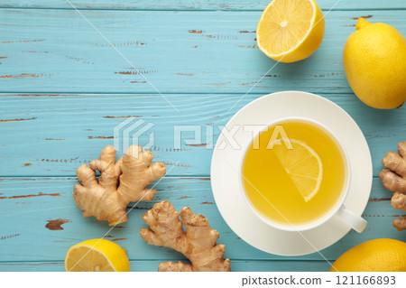 Ginger tea with lemon and honey on blue wooden background. Top view. Ginger tea with lemon and honey on blue wooden background. Top view. 121166893