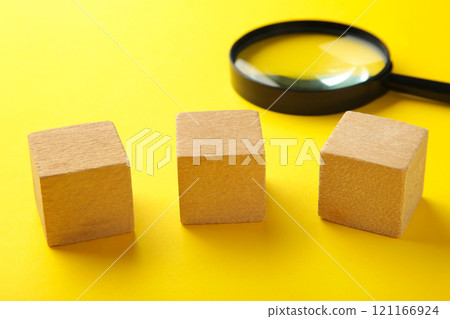 Wooden cubes with word SMM and magnifying glass on yellow background. 121166924