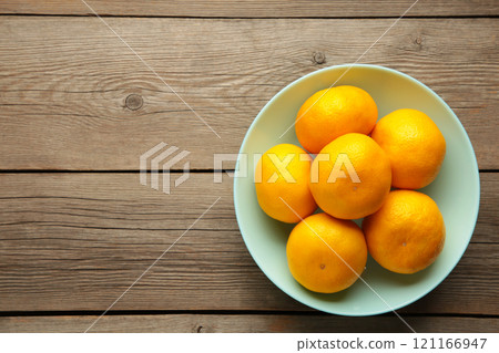 Fresh mandarin oranges fruit on mint bowl on wooden background. 121166947