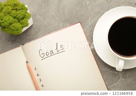 My Goals as memo on notebook with cup of coffee on grey background. My Goals as memo on notebook with cup of coffee on grey background. 121166958