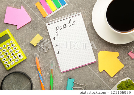 My Goals as memo on notebook with cup of coffee and chancellery on grey background. My Goals as memo on notebook with cup of coffee and chancellery on grey background. 121166959