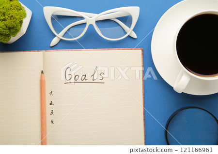 My Goals as memo on notebook with cup of coffee on blue background. My Goals as memo on notebook with cup of coffee on blue background. 121166961