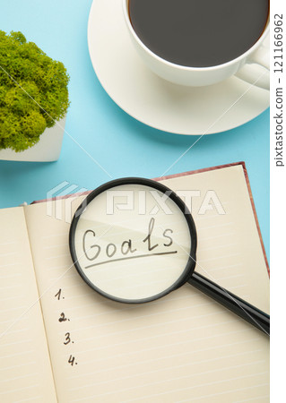 My Goals as memo on notebook with cup of coffee on blue background. My Goals as memo on notebook with cup of coffee on blue background. 121166962