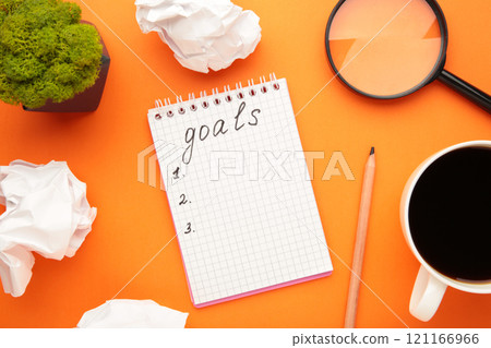 My Goals as memo on notebook with cup of coffee on orange background. My Goals as memo on notebook with cup of coffee on orange background. 121166966