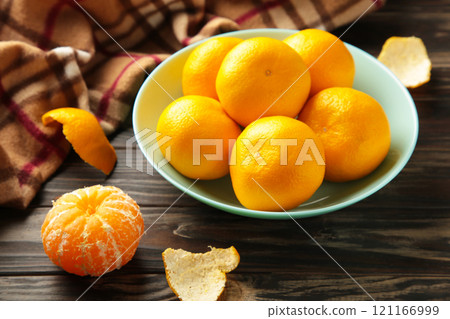 Fresh mandarin oranges fruit on mint bowl on brown wooden background. 121166999