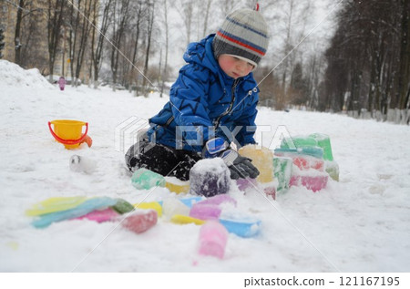 Little boy playing with colorful ice 121167195