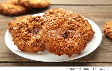 Peanut cookies on white plate on grey wooden background. Bakery products. 121167280