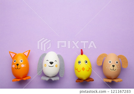 Easter holiday concept with cute handmade eggs, dogs, chicks and cat on purple background. Easter holiday concept with cute handmade eggs, dogs, chicks and cat on purple background. 121167283