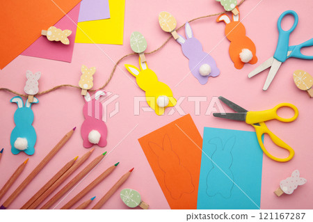 Easter bunnies handmade from colored paper, easy crafts for kids on pink background. 121167287