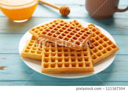 Belgian waffles. Belgian waffles with honey and tea. Freshly baked Belgian waffles. Belgian waffles. Belgian waffles with honey and tea. Freshly baked Belgian waffles. 121167304