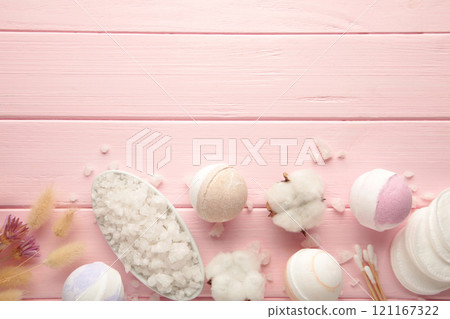 Aroma bath bombs in spa composition with dry flowers and salt on pink wooden background. Aroma bath bombs in spa composition with dry flowers and salt on pink wooden background. 121167322