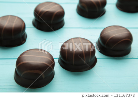 Chocolate sweets on a blue wooden background. Biscuit 121167378