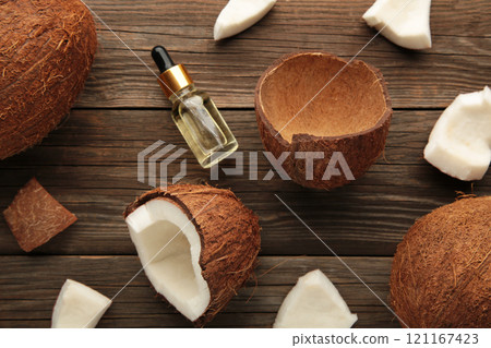 Fresh coconut and oil on brown wooden background. Healthy cooking. Fresh coconut and oil on brown wooden background. Healthy cooking. 121167423