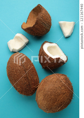 Coconut on a blue background. Halves and whole coconuts. Top view. 121167440