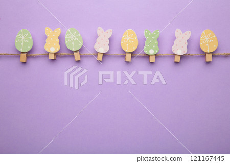 Easter eggs and bunnies on clothespin on purple background with copy space. 121167445