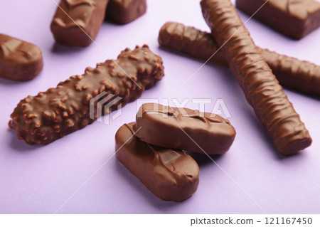 Mix of chocolate bars on purple background with copy space. Top view. 121167450