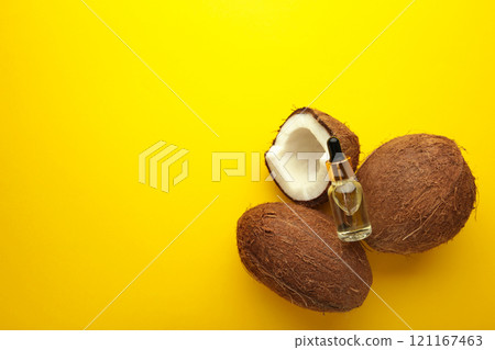 Coconut oil with coconut on yellow background. Top view Coconut oil with coconut on yellow background. Top view 121167463