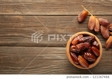 Wooden bowl of dried dates on grey wooden background. 121167488