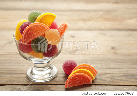 Jelly sugar candies in glass bowl on grey background. Jelly sugar candies in glass bowl on grey background. 121167608