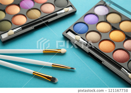 Professional makeup palette with brushes on blue background. Professional makeup palette with brushes on blue background. 121167738